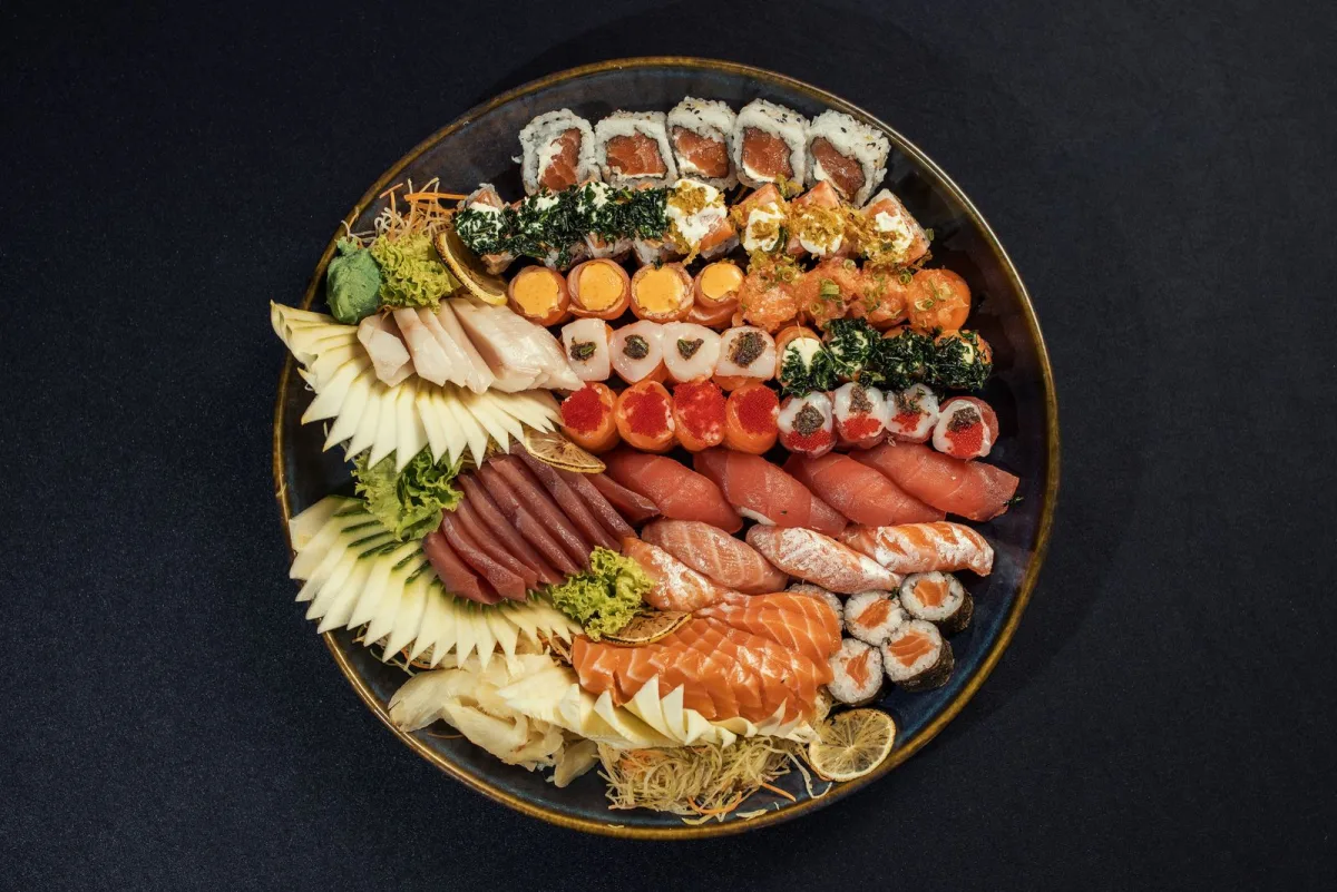 Große Auswahl an Sushi und Sashimi auf einer dunklen Platte